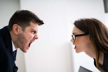 Side View Of Business People Quarreling At Desk In Officeの写真素材