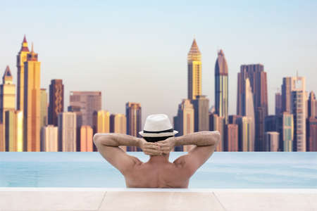 Man In Infinite Swimming Pool With Dubai Skyline In Backgroundの写真素材