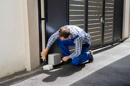 Repairman Fixing Broken Automatic Door In Buildingの写真素材