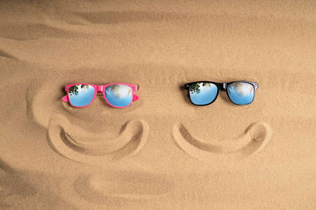 Sunglasses And Smiling Line On Sand At Beachの写真素材