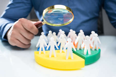 Businessperson Analyzing Market Segment Using Magnifying Glass
