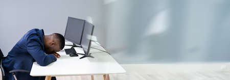 Portrait Of A Young Tired Businessman Sleeping At Desk
