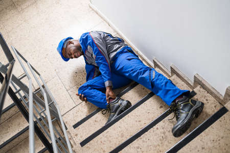 Handyman Touching His Injured Leg After Falling From Ladderの写真素材