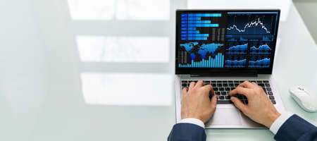 Close-up Of A Businessman's Hand Analyzing Graph On Laptop