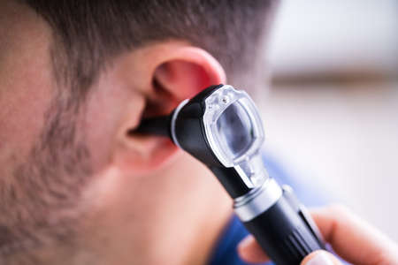 Close-up Of A Female Doctor Examining Patient's Ear With Otoscopeの写真素材