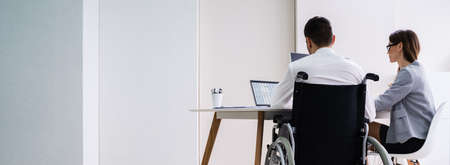 Two Young Businesspeople Working On Laptop At Workplaceの写真素材