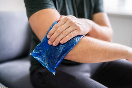 Man Using Ice Gel Pack On Injured Armの写真素材