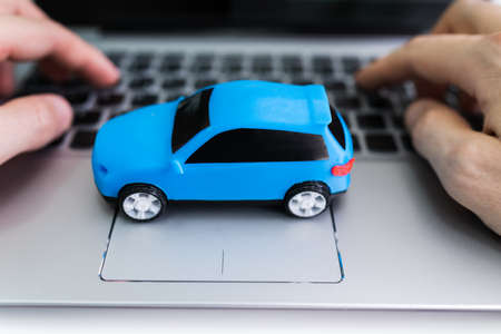 Close-up Of A Small Blue Car On Laptop Keypadの写真素材