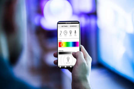 Person Controlling Light With App On Phone