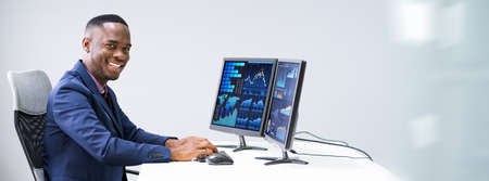 Close-up Of A Businessman's Hand Analyzing Graph On Computer At Workplace