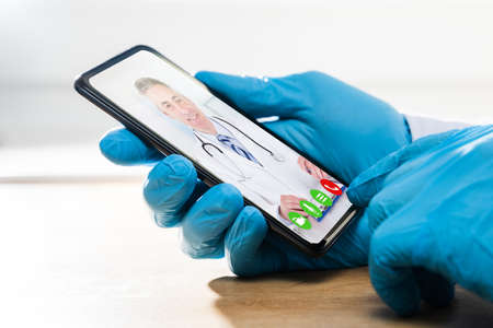 Man In Gloves On Coronavirus Quarantine Having Video Conference With Doctor