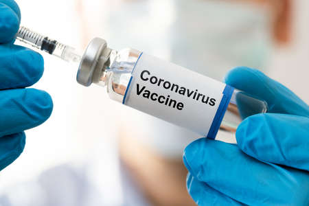 Doctor Hand In Gloves Holding Coronavirus Vaccineの写真素材