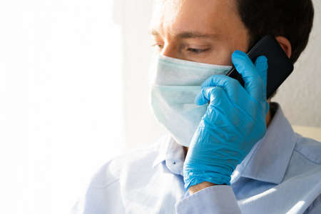 Man In Mask And Gloves Using Mobile Phone On Coronavirus Quarantine