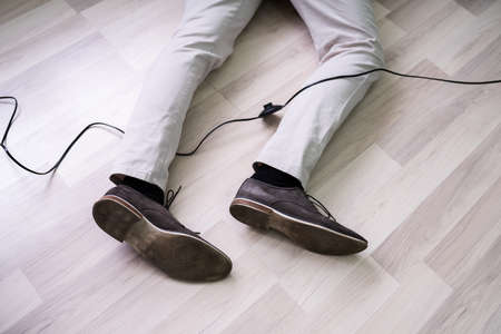 An Elevated View Of Man Stumbling With An Electrical Cord