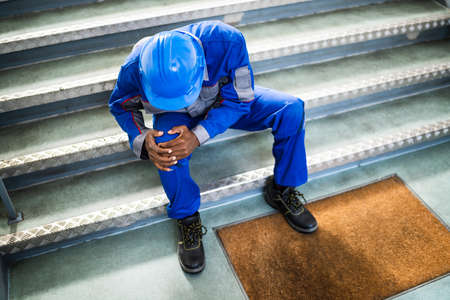 Handyman Sitting On Staircase After Slip And Fall Accidentの写真素材