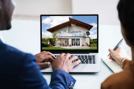 Close-up Of A Couple Looking For New House On Laptopの写真素材