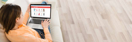 Woman Surfing Online On Laptop On Sofa And Shopping Online