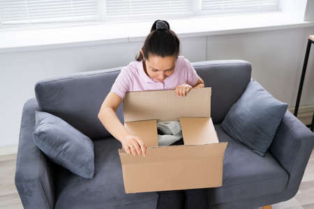 Happy Woman Opening Received Package From Online Shop