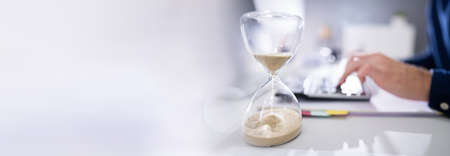 Late Invoice And Billing Deadline With Hourglass At Desk