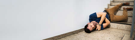 Slip And Fall Accident On Stairs. Worker Man Fallen Downの写真素材