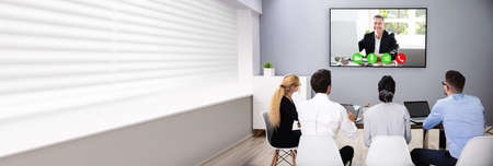 Business Team Watching Video Conference Call On TV