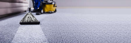 Professional Carpet Cleaning Service. Janitor Using Vacuum Cleanerの写真素材