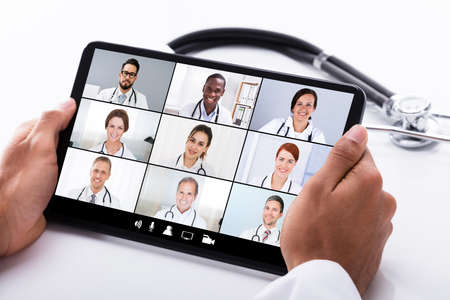 Doctor In Online Medical Video Conference With Diverse Team Of Hospital Workersの写真素材