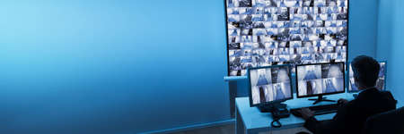 Man Monitoring CCTV Camera In Control Roomの写真素材