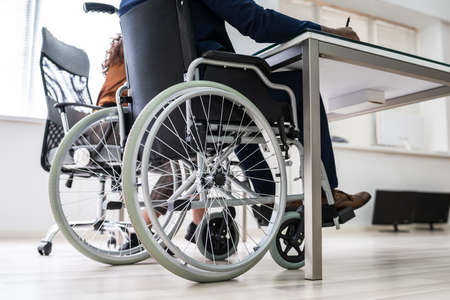 Disabled Businesswoman Sitting On Wheelchair In Officeの写真素材