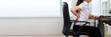 Back Pain Bad Posture Sitting In Officeの写真素材
