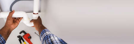 Plumber Cleaning Blocked Drain Sink Pipes At Homeの写真素材