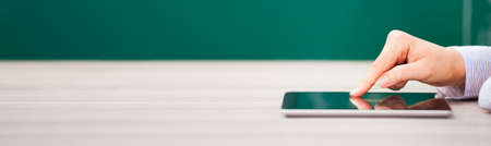 Teacher Using Digital Tablet For Online Learning In Classroomの写真素材