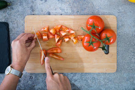 Woman Cooking Dinner At Home Cutting Vegetables