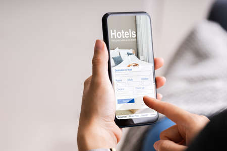 Holding Smart Phone Booking Hotel Online Using Websiteの写真素材