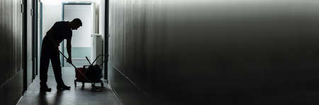 Silhouette Of A Male Janitor Cleaning Corridorの写真素材