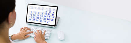 Woman Looking At Calendar On Laptop Computerの写真素材