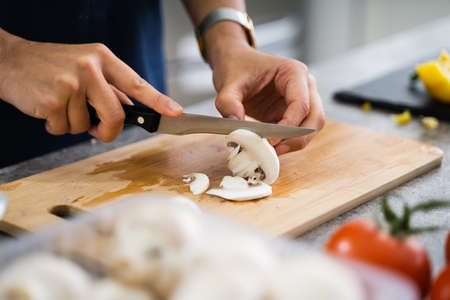 Woman Cooking Dinner At Home Cutting Mushrooms