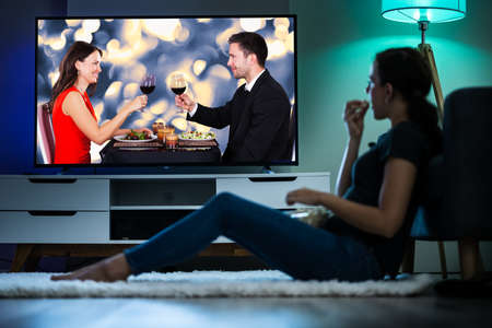 Woman Watching TV On Couch Or Sofa. Watch Televisionの写真素材