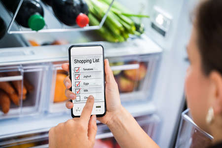 Convenient Grocery Shopping List Phone App Near Fridgeの写真素材