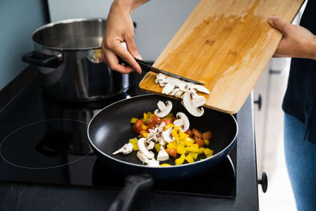 Woman Cooking Health Vegetarian Meal At Home