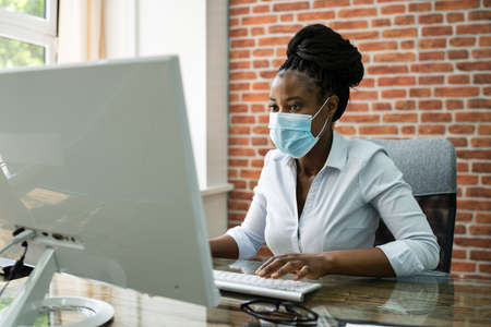 Professional African Woman Business Employee Typing In Officeの写真素材