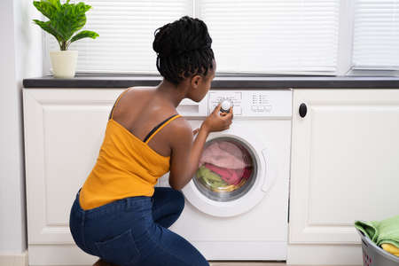 Person Hand Setting Washing Machine For Clothes Laundryの写真素材