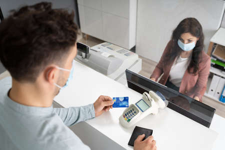 Store Shop Cashier Or Hotel Reception With Medical Maskの写真素材