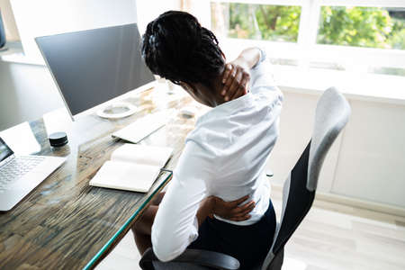 Back Pain Bad Posture Woman Sitting In Officeの写真素材