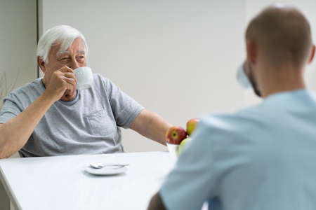 Caretaker In Retirement Home With Elder Manの写真素材