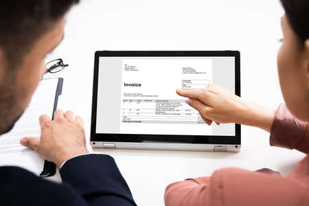 Accountant Checking Business Invoice Or Bill On Laptop