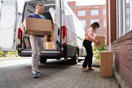 Couple Moving Boxes From Van Or Truck Together Outdoorsの写真素材