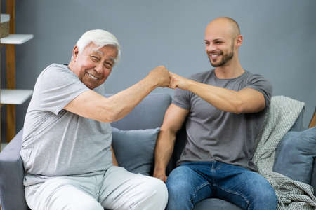 Happy Grandpa Making Fist Bump With His Grandsonの写真素材