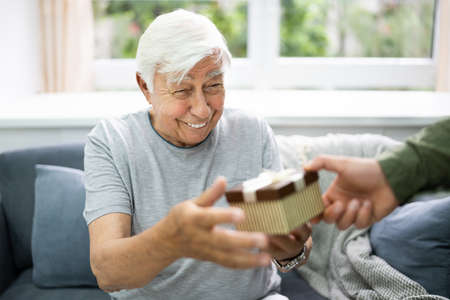 Senior Citizen Receiving Celebration Gift At Nursing Home