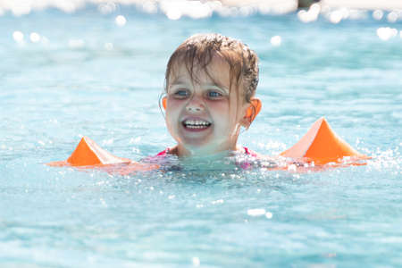 Child Girl In Swimming Pool Playing And Learning
